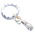 Dettaglio del portachiavi a bracciale in pelle PU bianca con stampa cactus e nappa - Stampa Mucca