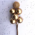 Macro shot of matte gold berry clusters and metallic frosted beads for gift decor - Gold