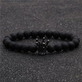 Détail d'un bracelet en perles noires mates avec un pendentif couronne sur fond scintillant - Noir Mat Couronne Noir Fusil