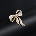 Élégante broche nœud dorée avec cristaux blancs sur un socle de présentation noir - XD9123 Or