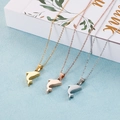 Tres collares de delfín en oro, oro rosa y plata sobre una caja de regalo - Delfín Pequeño / Dorado