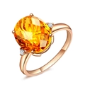 Detailopname van roségouden ring met ovale oranje citrien en zijdelingse diamanten - Ring