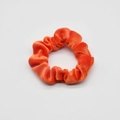 Detail of vibrant orange velvet scrunchie showing soft texture and high elasticity - Orange