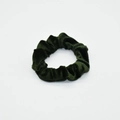 Detail shot of a dark green velvet scrunchie showing fabric texture and elastic design - Dark Green