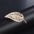 Elegant gold-tone leaf brooch with sparkling crystals on a black display stand - Gold Leaf Shape