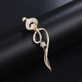 Elegant gold flower brooch with white crystal rhinestones on a black jewelry stand - Gold Streamline Flower