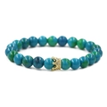 Bracciale di perline blu-verdi con ciondolo a corona dorata su sfondo bianco pulito - Corona d'Oro Pietra di Fenice