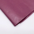 Primer plano de papel seda fucsia doblado mostrando textura suave y gran detalle - Burdeos