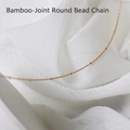 Close-up of a 18K gold plated stainless steel bamboo bead chain necklace on white fabric - Bamboo Bead Chain / 45 cm / Gold