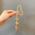 Dettaglio di un fermaglio per capelli a farfalla dorata con lunghe nappe e piccoli ciondoli - Farfalla - Nappa Farfalla / Oro