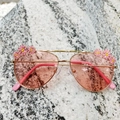 Close-up of golden frames with pink lenses and small enamel daisy flower decorations - Pink
