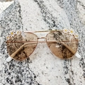 Detail of kids gold metal aviator sunglasses with white daisy floral decorations - Champagne