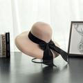 Detail of wide brim straw sun hat featuring a large black bow ribbon on a metal stand - M (56-58cm) / Flesh Pink