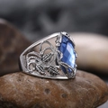 Macro shot of oversized marquise blue crystal ring with vintage vine detailing on pebbles - US 6 / Blue