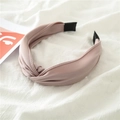 Pink fabric headband with handmade knot design on white textured background - Pink