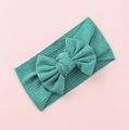 Macro detail of teal knit baby headband featuring a large textured ribbed fabric bow - Deep Lake Blue