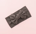 Detailed texture of brown ribbed knit baby headband with a decorative large bow - Khaki