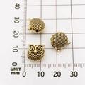 Three gold owl-shaped spacer beads for DIY bracelets shown on a millimeter scale grid - Owl Style (10133)