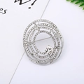 Detail of spiral brooch with white rhinestones and a central crystal on white background - 27# Silver Spiral Rhinestone
