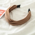 Detalle de una diadema de tela marrón con nudo sobre fondo de tela blanca drapeada - Café Claro