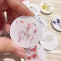 Macro detail of round resin phone socket with pink dried flowers and glitter accents - Pink Baby's Breath