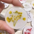 Macro shot of handmade resin phone socket with yellow dried flowers and gold glitter flakes - Yellow Baby's Breath
