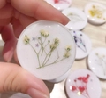 Close-up of handmade resin phone grip featuring white dried flowers and silver glitter - White Baby's Breath