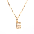 Détail d'un collier doré avec un pendentif lettre E serti de cristaux brillants - Lettre E