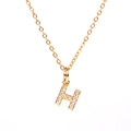 Detailed close-up of a golden H-letter pendant necklace featuring paved zircon stones - Letter H
