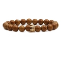 Bruine houten kralenarmband met een gouden kroonbedel op een witte achtergrond - Houtnerf Kroon