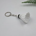 Dettaglio di un portachiavi a forma di volano bianco con anello in metallo su sfondo - Bianco