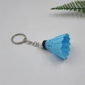 Primo piano di un portachiavi a forma di volano da badminton blu con catena in metallo - Blu