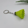 Macro shot of a neon green badminton shuttlecock keychain on a white background - Green