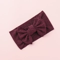Detail of a deep burgundy knitted baby headband with a large decorative bow - Burgundy