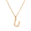 Close-up of a gold-plated necklace featuring a letter U pendant with sparkling crystals - Letter U