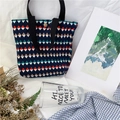 Dettaglio della borsa a pieghe blu navy con stampa geometrica colorata e bottone a pressione - Stile triangolo geometrico blu scuro (rombo blu notte)
