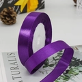 Deep purple satin ribbon 1.5cm wide for gift wrapping on a floral magazine background - Purple