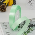 Roll of mint green satin ribbon with soft sheen for elegant gift wrapping and DIY crafts - Light Green