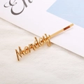 Minimalist gold alloy hair clip featuring an artistic Monday letter design for women - Monday