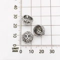 Three antique silver lion head beads for DIY bracelets shown on a millimeter scale grid - Lion Head Style (10128)