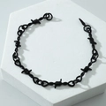 Unisex black thorn wire chain bracelet with punk aesthetic on white display stand - Bracelet / Black