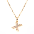 Macro shot of gold letter X pendant necklace featuring micro-set sparkling white zircons - Letter X