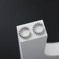 Dettaglio di orecchini a clip a C in argento con perline su supporto geometrico - Un Paio / Argento
