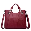 Fashionable burgundy leather handbag for women featuring silver hardware on white background - Burgundy