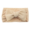 Infant nylon headband with large apricot knitted bow detail on white background - Deep Beige