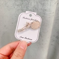 Broche raquette de tennis en or rose avec cristaux scintillants sur carte blanche - A7-37