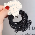 Detailed view of elastic black bow hair ties set on white cat-shaped cardboard - Black