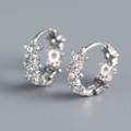 Macro shot of silver star-shaped hoop earrings with sparkling cubic zirconia inlay - 925 Silver / White Gold (Pair)