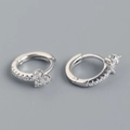 Macro shot of silver floral hoop earrings with sparkling butterfly zircon embellishments - 925 Silver / Platinum (White Stone)