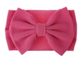 Detailed view of bright pink baby headband featuring a large ribbed knit fabric bow - Rose Red